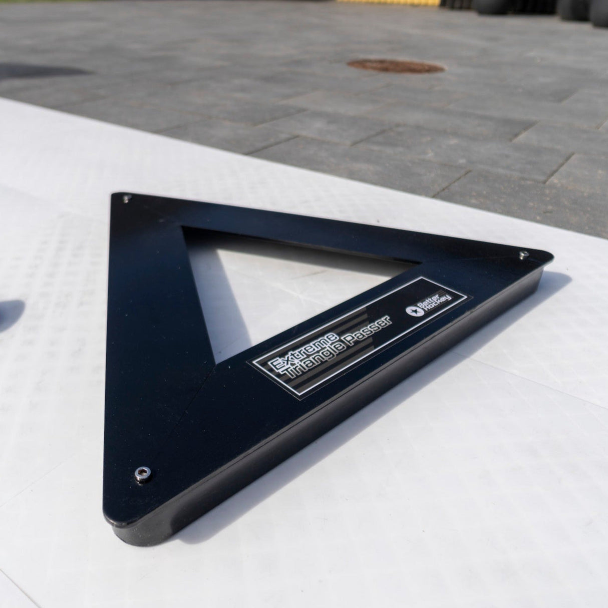 Extreme Hockey Triangle Passer displayed on a smooth surface, showcasing its sturdy steel frame and three passing slots, ideal for training.