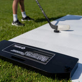 Extreme Hockey Flooring Tiles Passing Kit on grass, featuring a player practicing passing with a puck and hockey stick.
