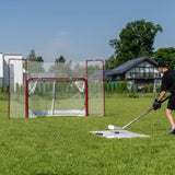En spelare skjuter puckar mot ett hockeymål med backstop i gräsmatta, perfekt för hemmaträning och precision.