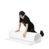 En pojke i svart tröja rullar ut en skottplatta för hockeyträning, idealisk för skott och passningar.