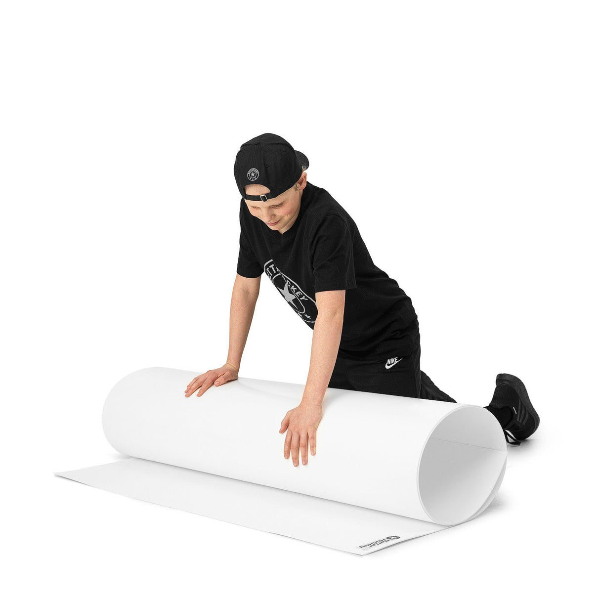 En pojke rullar ut en stor skottplatta för hockeyträning. Perfekt yta för att utveckla spelkunskaper hemma.