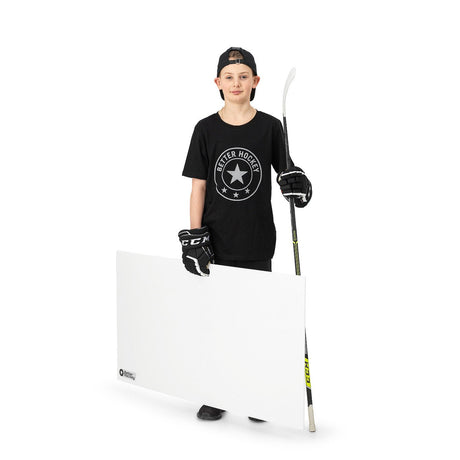 Ung hockeyspelare med skottplatta hockey 120x60 cm, hållande klubba, i svart t-shirt och handskar. Perfekt för träning hemma.