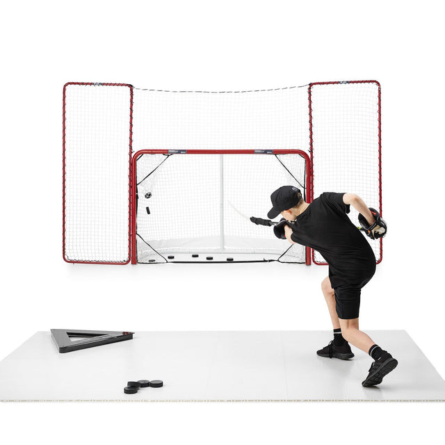 Skottramp teknikpaket hockey i bruk, spelare tränar skott mot mål med puckar på träningsyta.